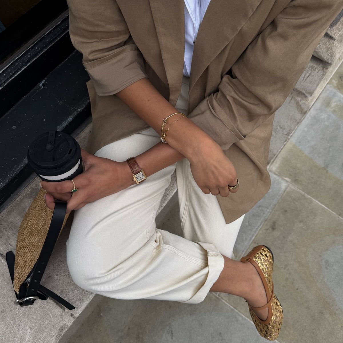 An image of @cocobeautea wearing one of the best linen blazers with white jeans and gold mesh ballet flats while in London.