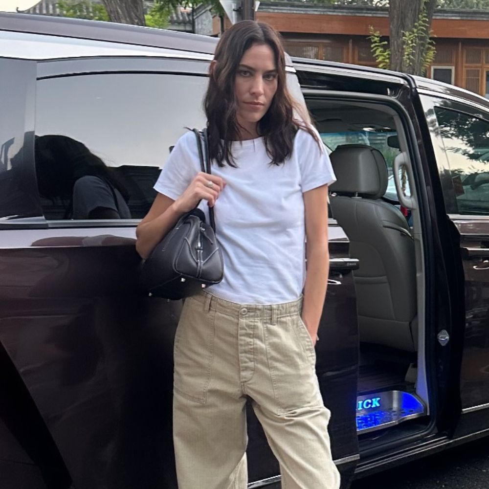 Influencer @alexachung wears a white t-shirt with beige jeans, black ballet flats with a black handbag.