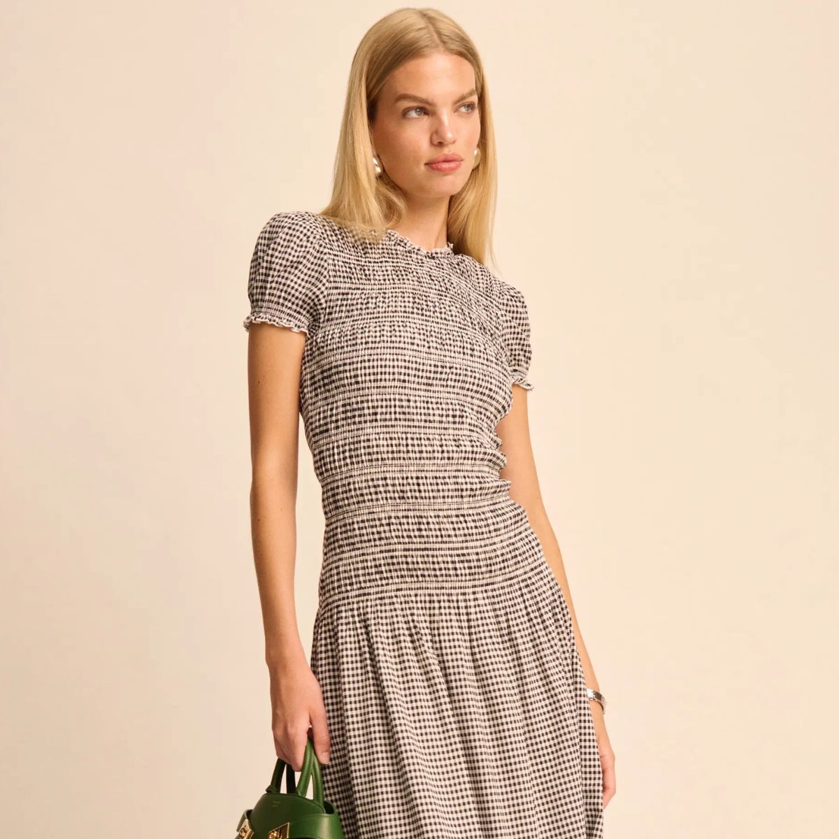 Woman wears brown coat, black top, blue jeans