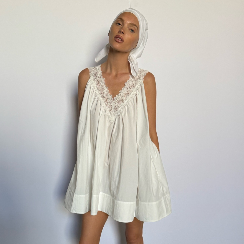 Elsa Hosk wears a white sleeveless minidress with black biker boots and a white headscarf.